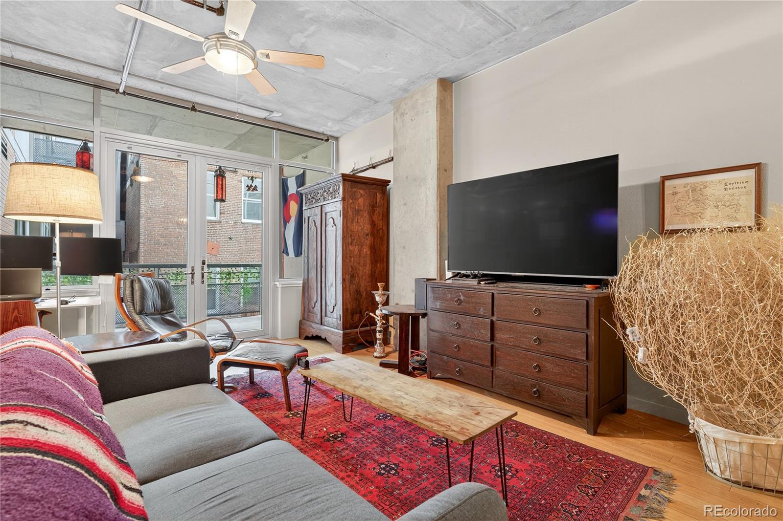 1401 Wewatta Street, Unit 305 Denver, CO 80202 - Photo 12 of 45 a living room with furniture and a flat screen tv