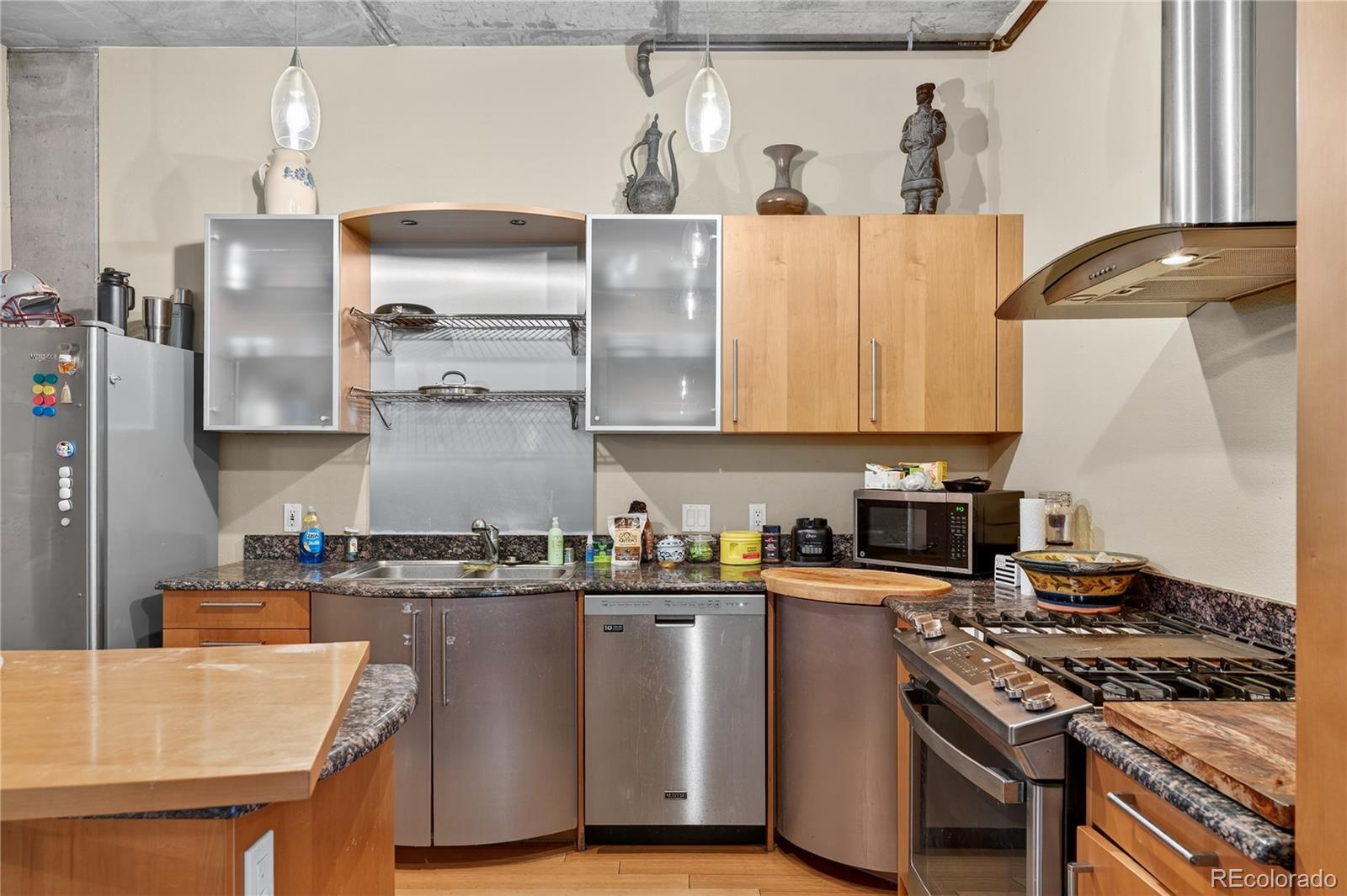 1401 Wewatta Street, Unit 305 Denver, CO 80202 - Photo 19 of 45 a kitchen with stainless steel appliances granite countertop a stove a sink and a refrigerator