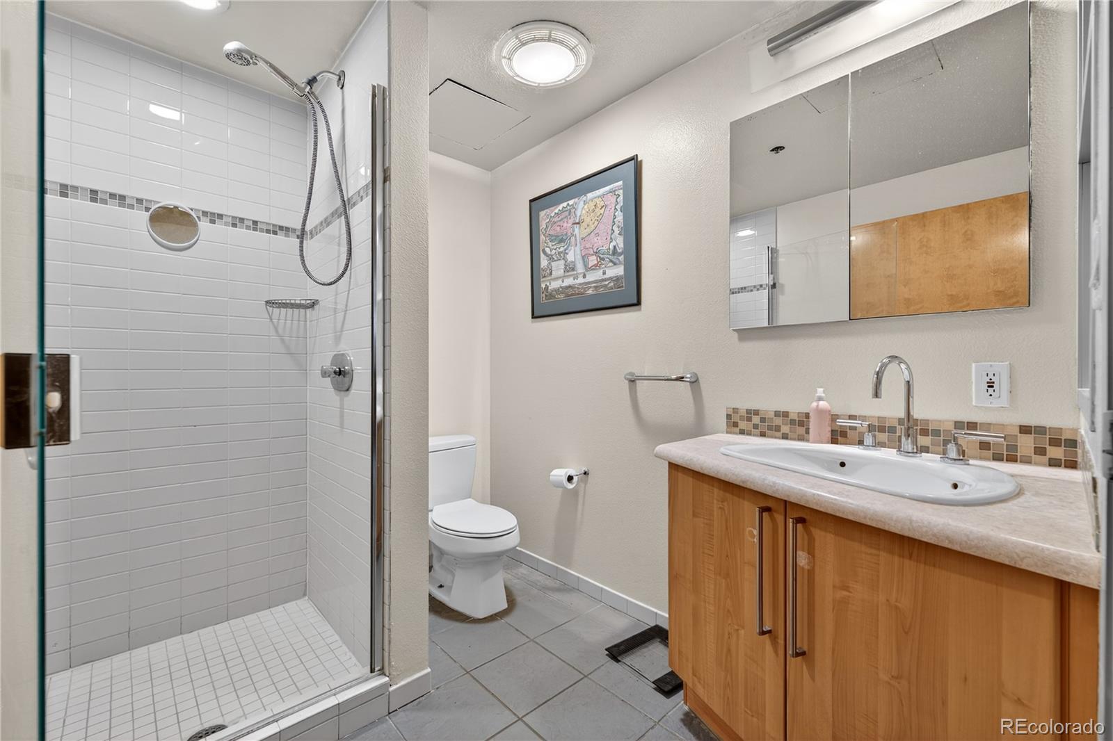 1401 Wewatta Street, Unit 305 Denver, CO 80202 - Photo 21 of 45 a bathroom with a granite countertop sink toilet and shower