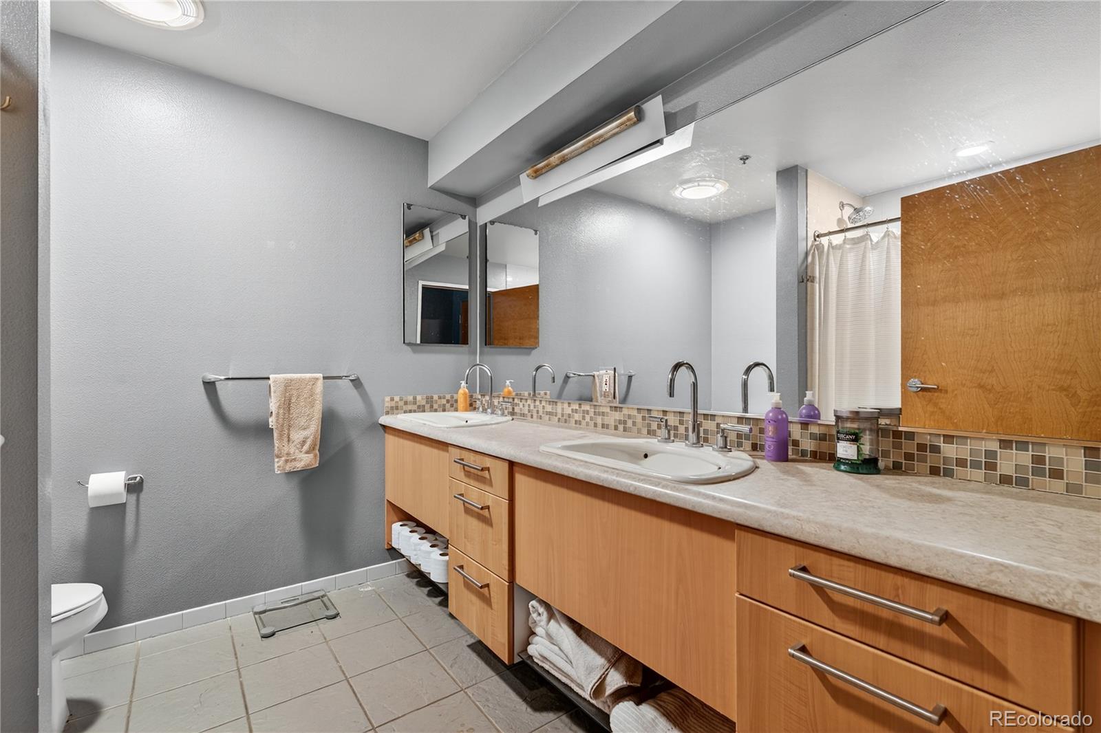 1401 Wewatta Street, Unit 305 Denver, CO 80202 - Photo 26 of 45 a spacious bathroom with a double vanity sink and mirror