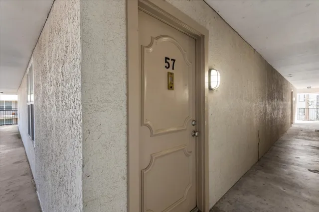 a view of a hallway with wooden floor and closet area