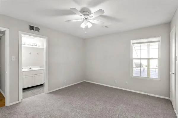 an empty room with windows and cabinet