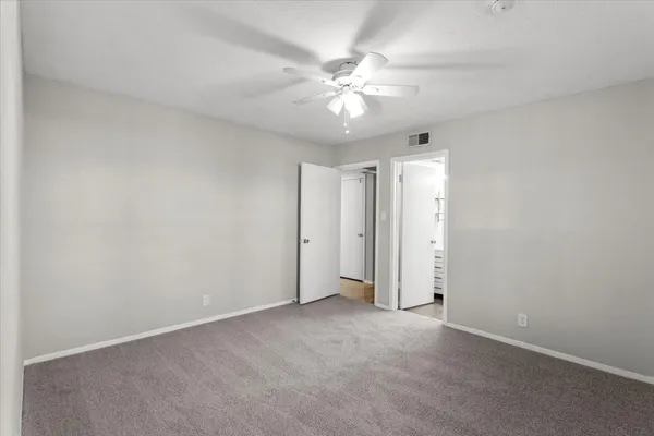 an empty room with a fan and a fan