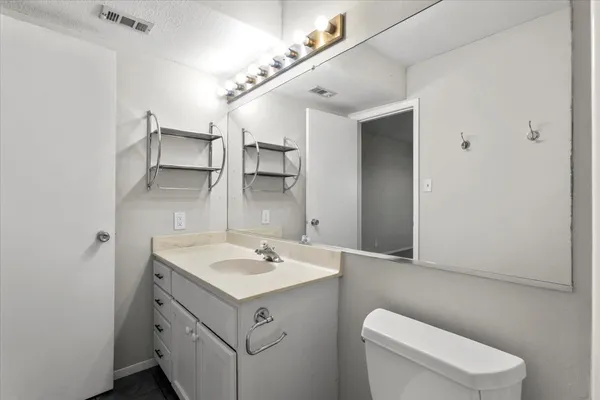 a bathroom with a sink a toilet and mirror