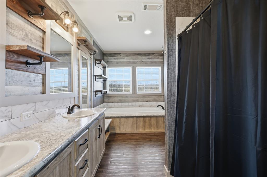 151 Private Road 3814 Springtown, TX 76082 - Photo 16 of 29 a bathroom with a granite countertop sink a mirror and a bathtub
