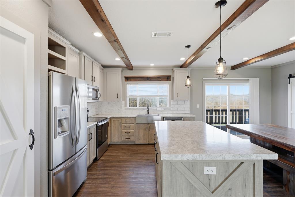 151 Private Road 3814 Springtown, TX 76082 - Photo 5 of 29 a kitchen with stainless steel appliances granite countertop a refrigerator a sink dishwasher a stove and white cabinets with wooden floor