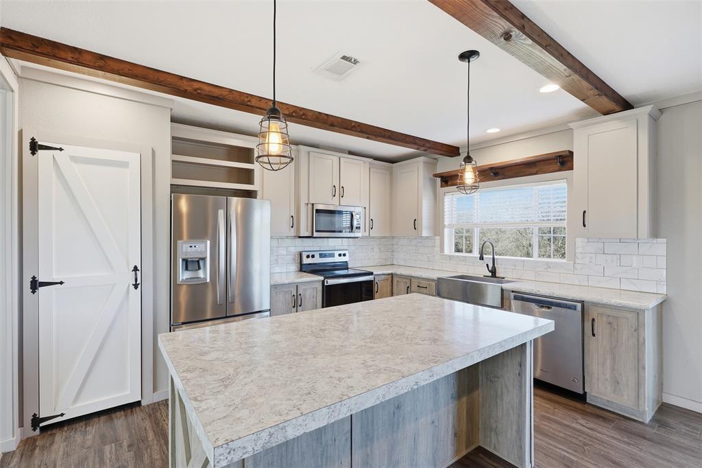151 Private Road 3814 Springtown, TX 76082 - Photo 7 of 29 a kitchen with stainless steel appliances granite countertop a sink a stove and refrigerator