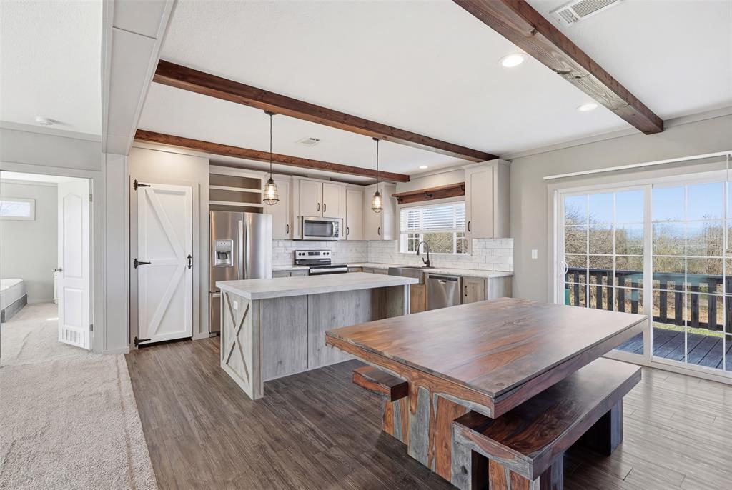 151 Private Road 3814 Springtown, TX 76082 - Photo 10 of 29 a kitchen with a table chairs refrigerator and cabinets