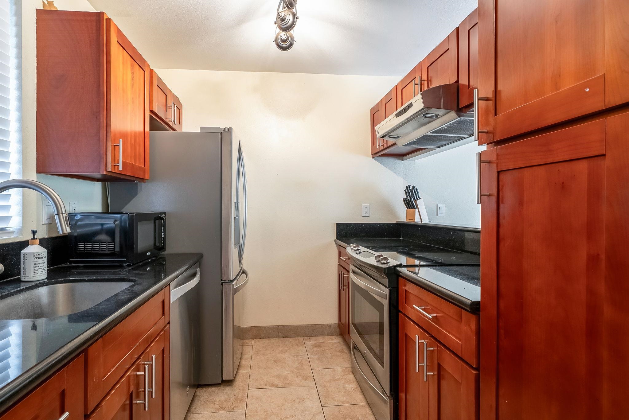 480 Kenolio Road, Unit 6204 Kihei, HI 96753 - Photo 17 of 44 a kitchen with stainless steel appliances granite countertop a sink stove and refrigerator