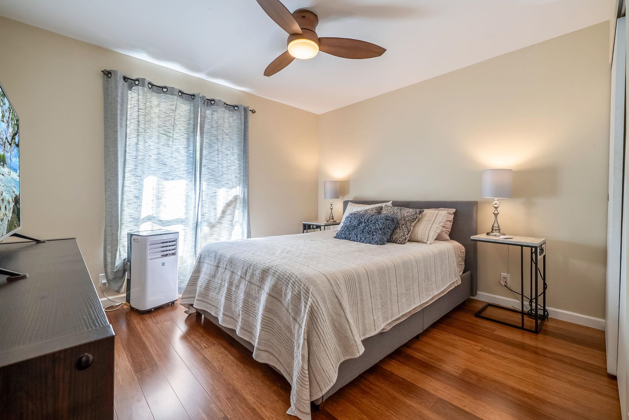 480 Kenolio Road, Unit 6204 Kihei, HI 96753 - Photo 24 of 44 a bedroom with a bed and wooden floor