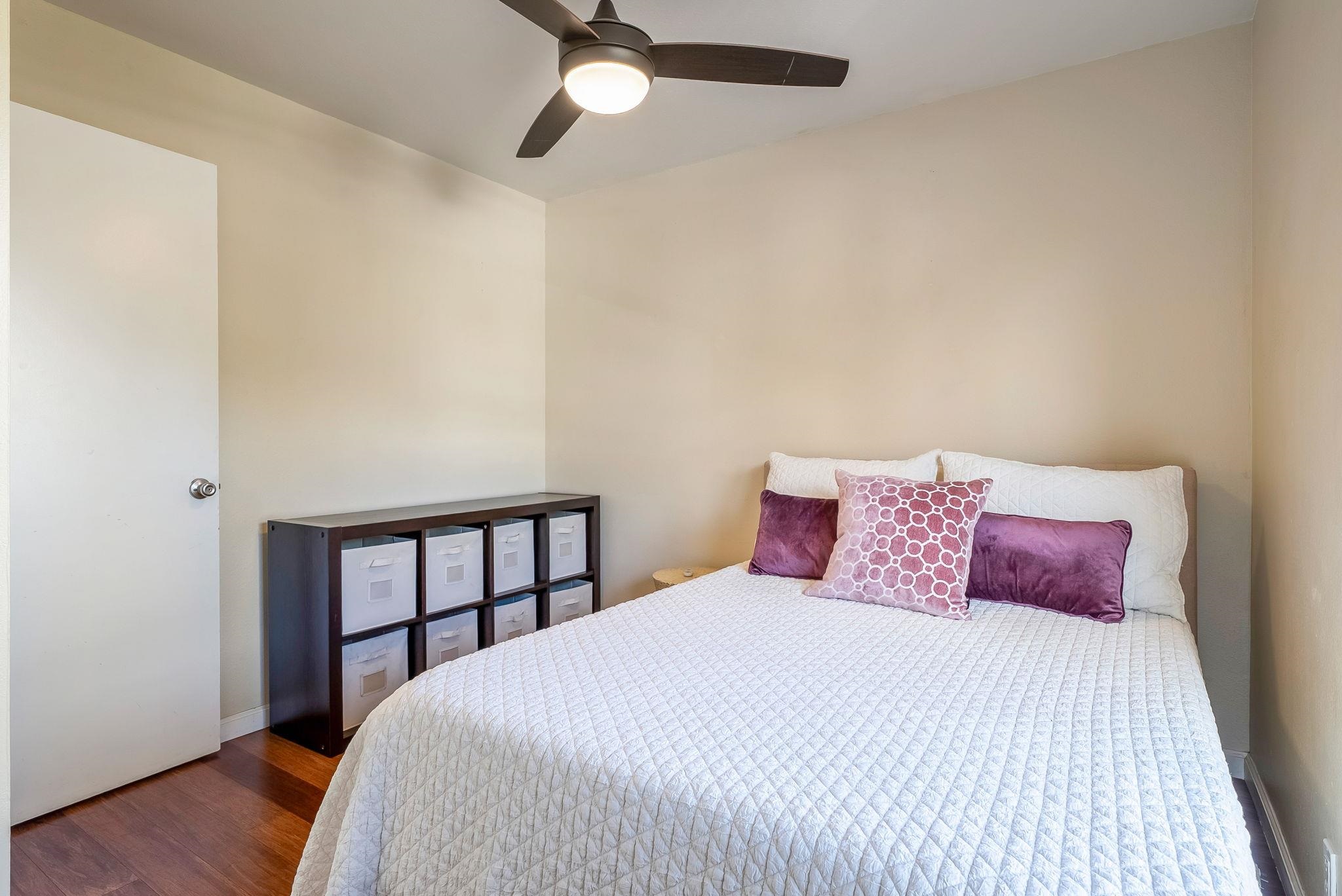 480 Kenolio Road, Unit 6204 Kihei, HI 96753 - Photo 29 of 44 a bedroom with a bed and wooden floor