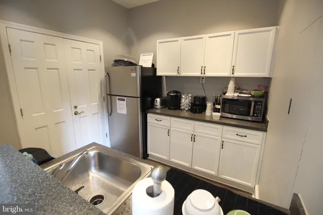 a kitchen with a sink a refrigerator and cabinets