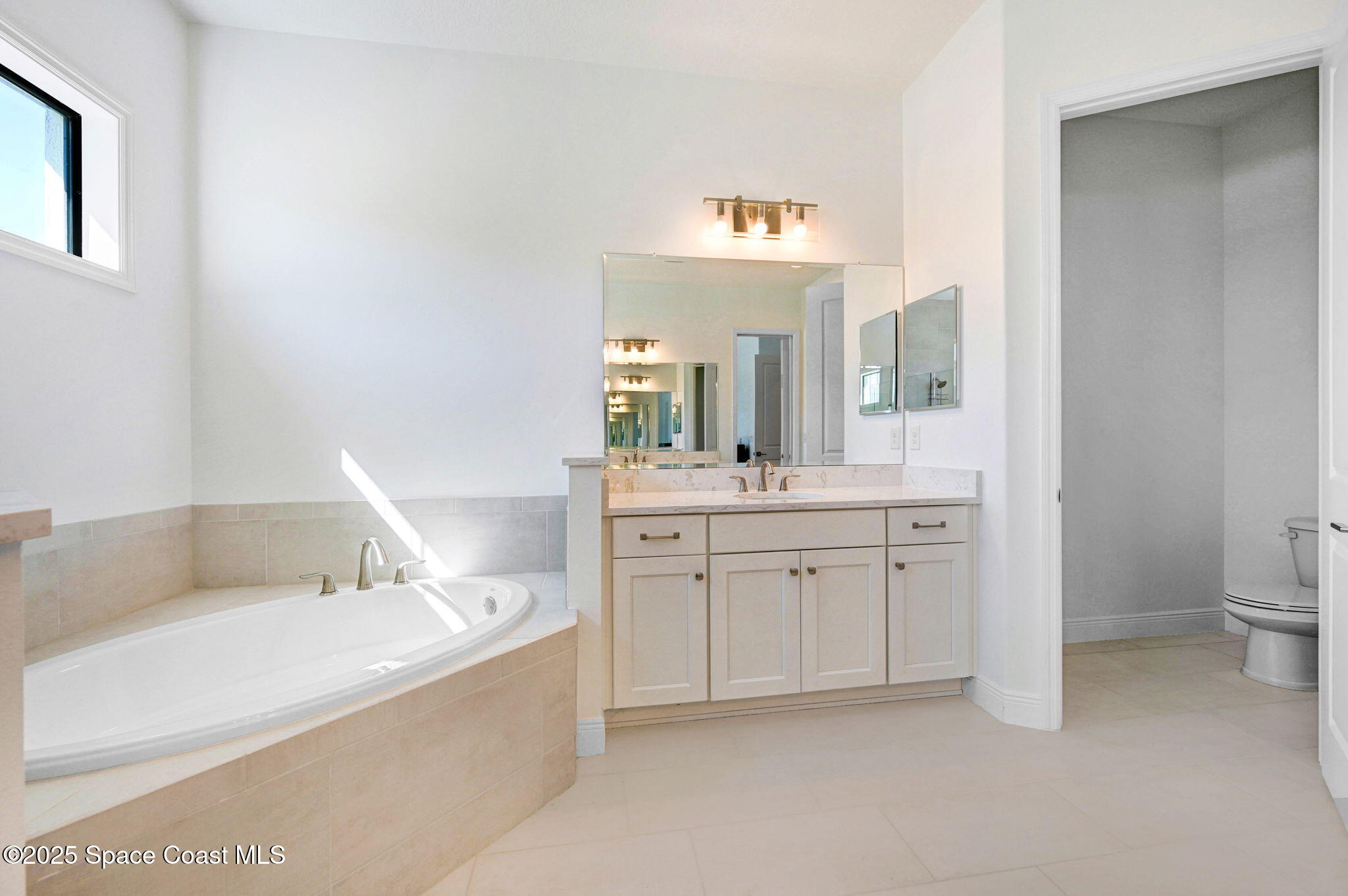 2366 Addison Drive Melbourne, FL 32940 - Photo 38 of 43 a en suite bathroom with a granite countertop sink mirror and a bathtub