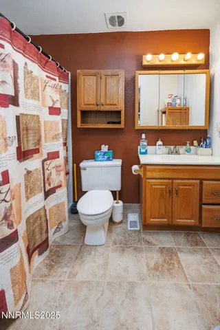 a bathroom with a toilet a sink and a large mirror