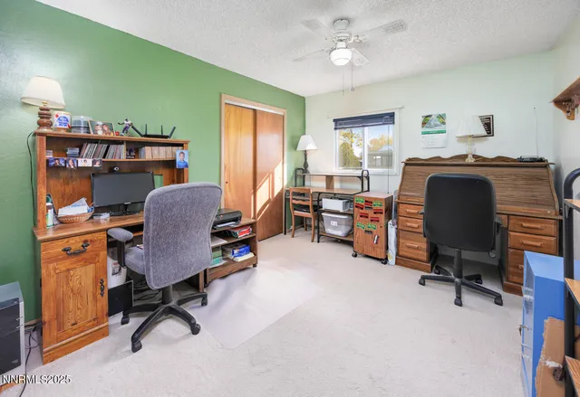a view of a workspace with furniture and a window