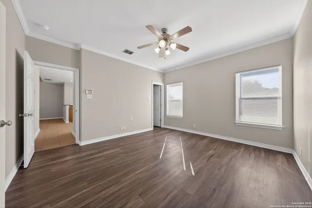 a view of an empty room with wooden floor