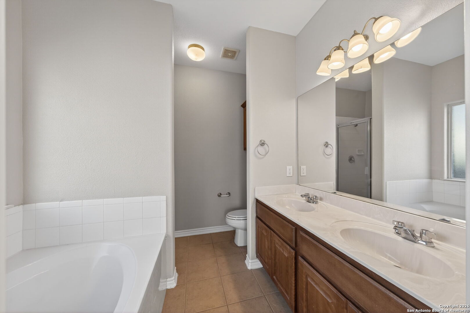 15709 Fair Lane Selma, TX 78154 - Photo 17 of 32 a spacious bathroom with a double vanity sink mirror and a bathtub