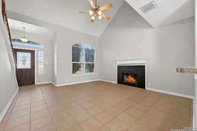 an empty room with windows and fireplace