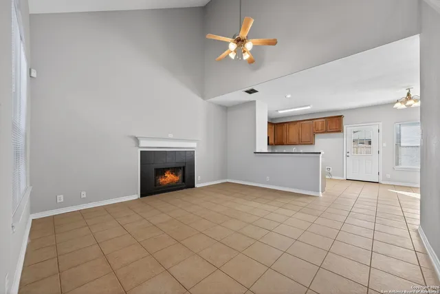 an empty room with windows and fireplace