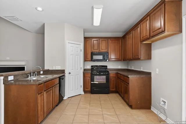 a kitchen with stainless steel appliances granite countertop a stove top oven a sink dishwasher and a refrigerator