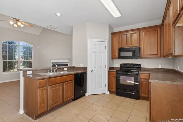 a kitchen with stainless steel appliances granite countertop a stove top oven a sink dishwasher and a refrigerator