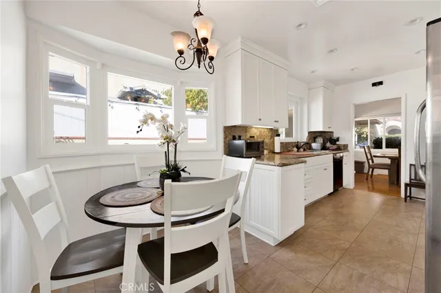 a kitchen with stainless steel appliances a table and chairs in it