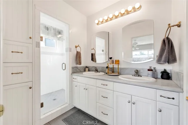 a bathroom with a double vanity sink mirror and bathtub