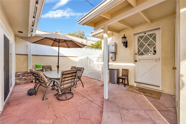 a view of a patio with a table and chairs under an umbrella