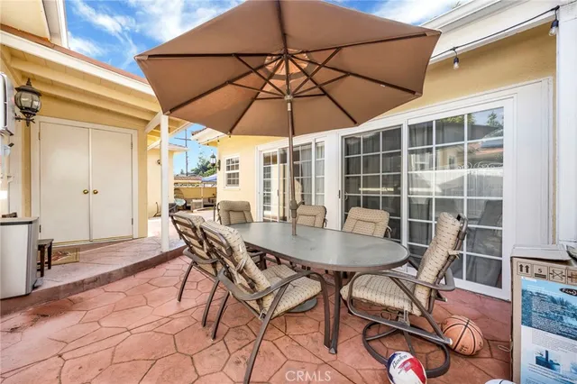 a patio with a table and chairs under an umbrella