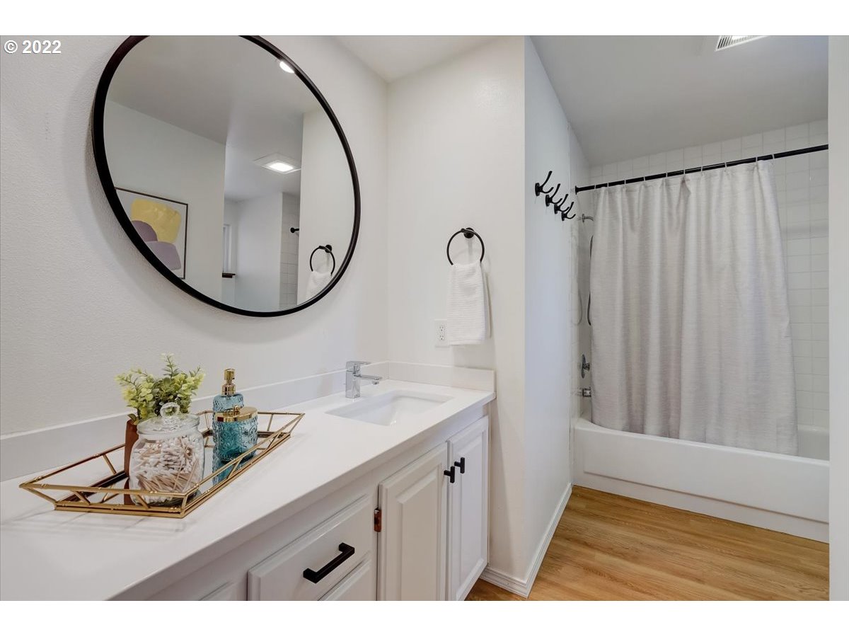 15645 Northwest Perimeter Drive Beaverton, OR 97006 - Photo 23 of 32 a bathroom with a sink a mirror and a painting on the wall