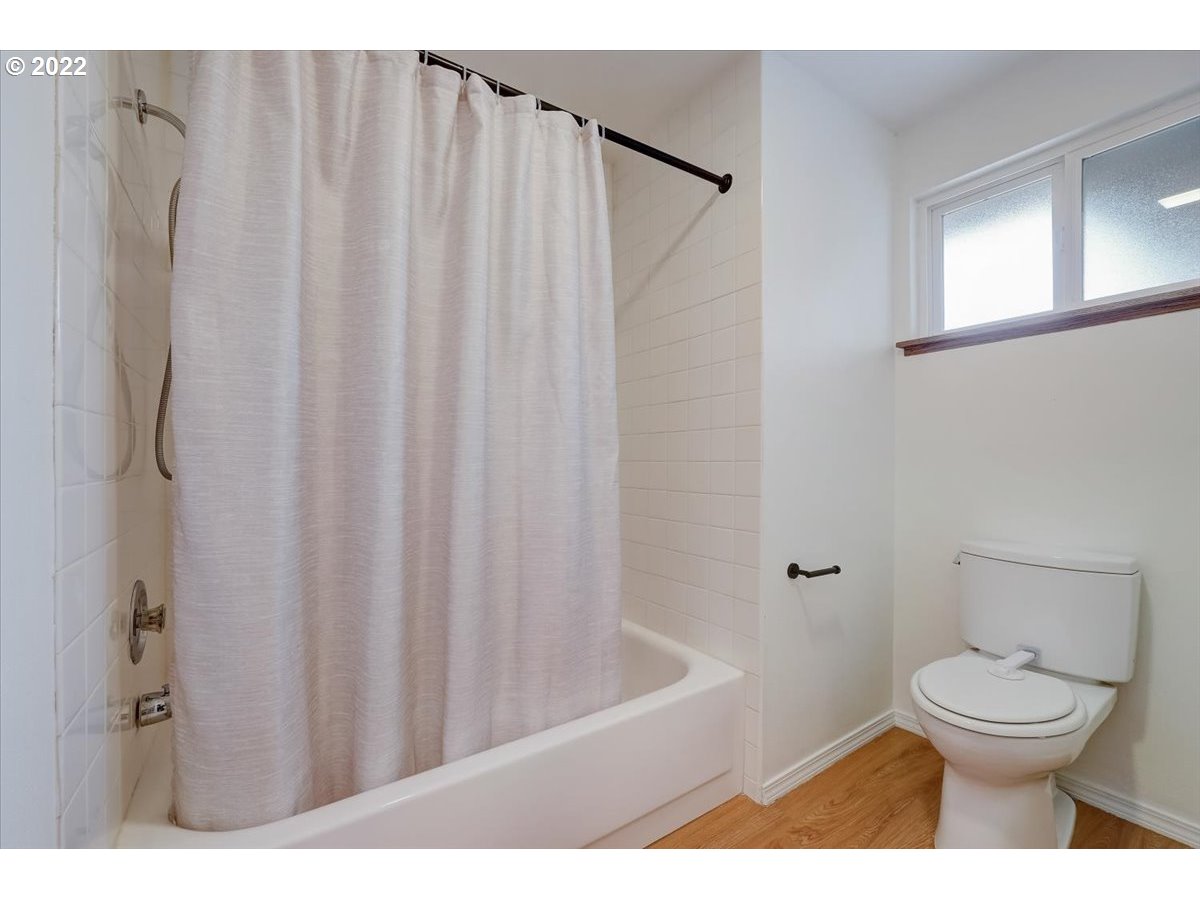 15645 Northwest Perimeter Drive Beaverton, OR 97006 - Photo 24 of 32 a bathroom with a toilet and a shower curtain