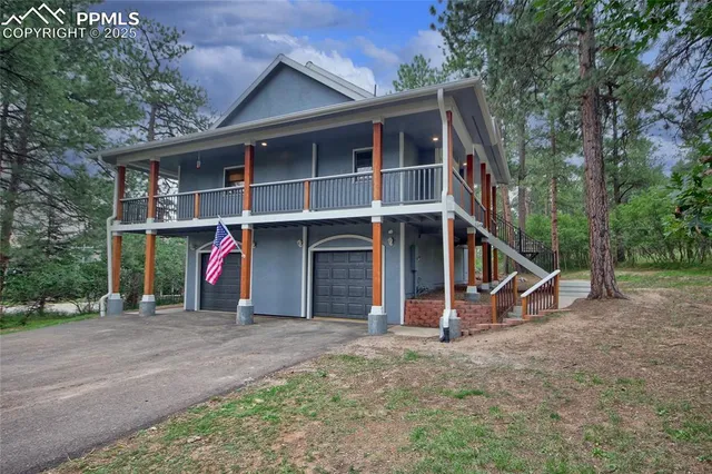 a view of wooden house with large trees and wooden fence