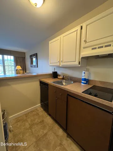 a kitchen with stainless steel appliances granite countertop a sink a stove and white cabinets