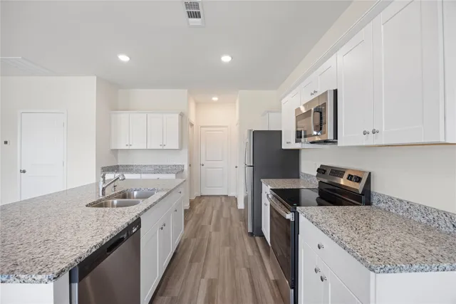 a kitchen with a sink stove and cabinets