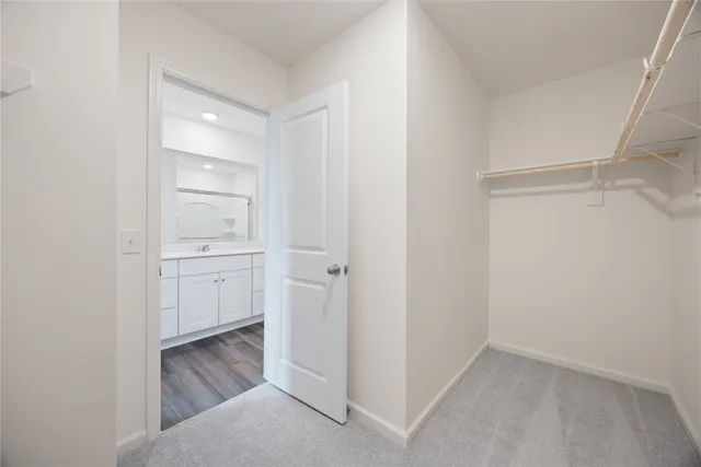 a view of walk in closet with empty racks