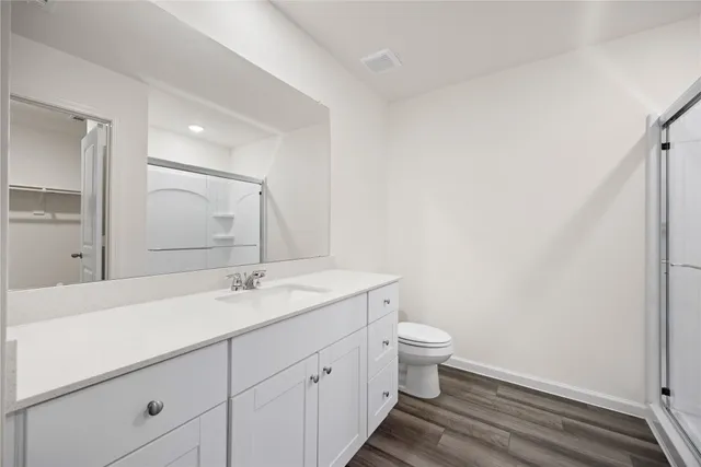 a bathroom with a granite countertop sink a toilet and a mirror