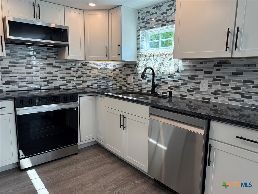 8 Marshall Road Port Lavaca, TX 77979 - Photo 13 of 31 a kitchen with sink a microwave a stove and cabinets