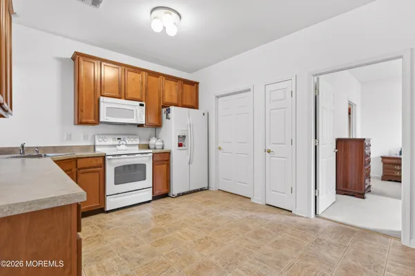 a view of kitchen with stainless steel appliances granite countertop a stove top oven a sink and a refrigerator