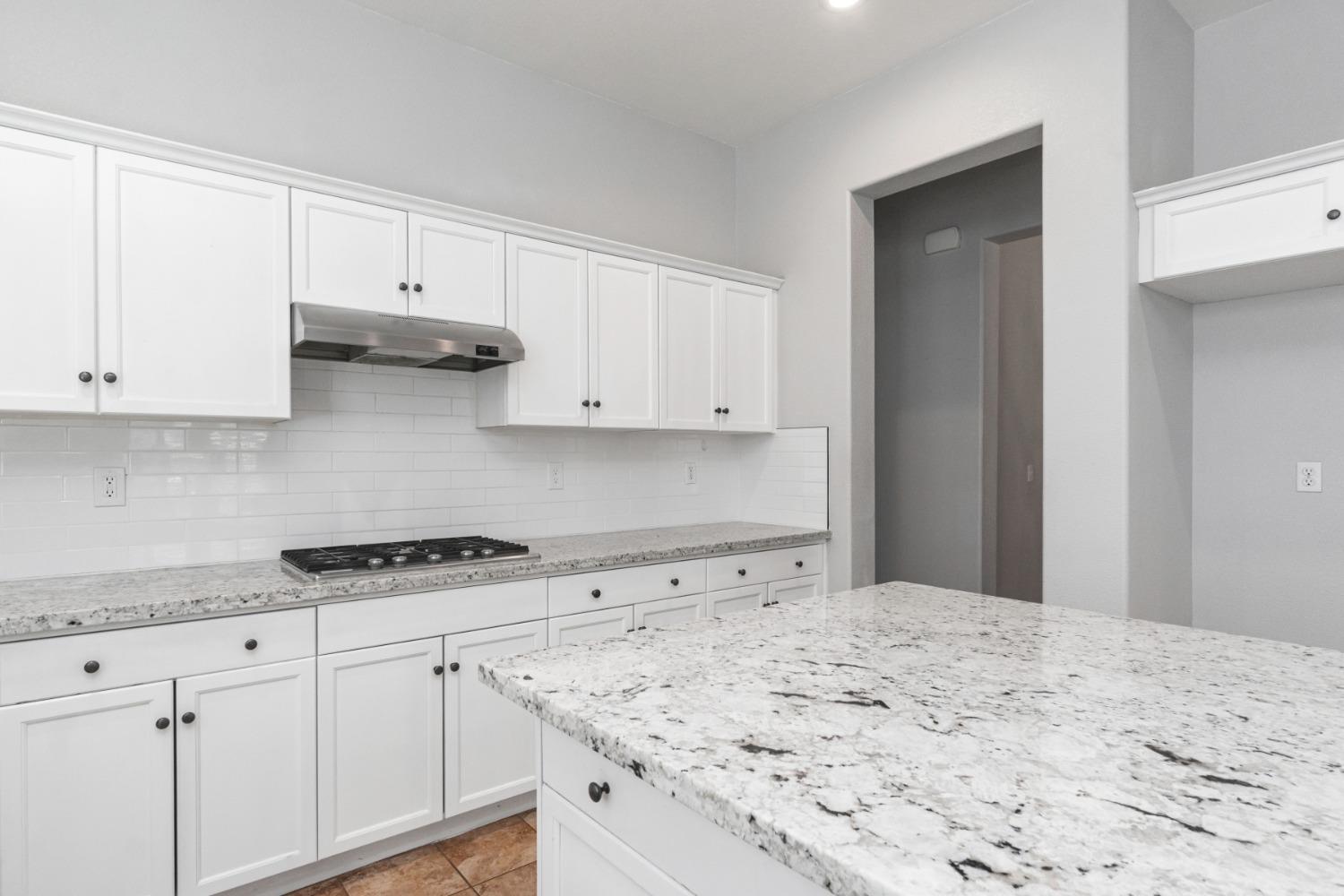 3307 Buckingham Avenue Clovis, CA 93619 - Photo 11 of 32 a kitchen with white cabinets and a stove with white countertops
