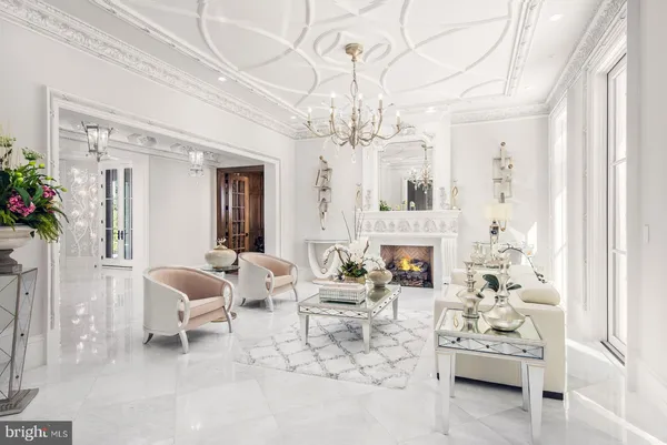 a living room with furniture a chandelier and a fireplace