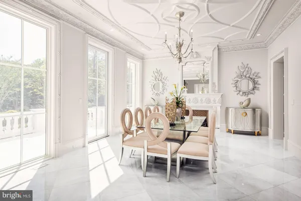 a dining room with furniture and large windows