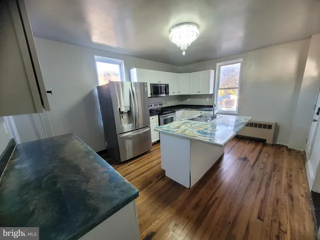 a kitchen with wooden floors and appliances