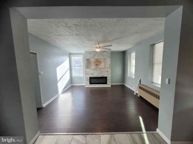 an empty room with windows and fireplace