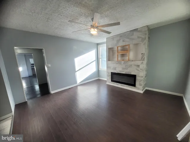 an empty room with wooden floor and fireplace