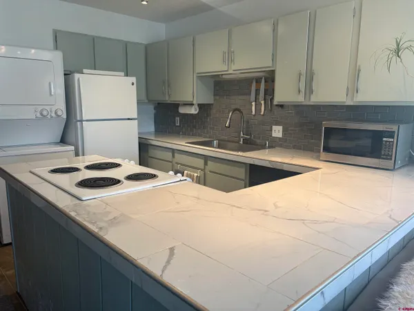 a kitchen with a sink a stove a refrigerator and cabinets