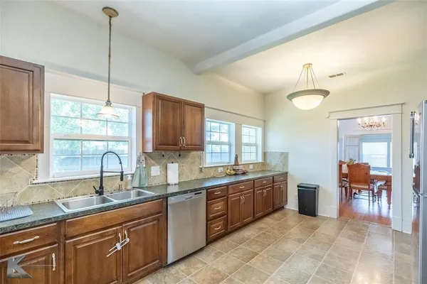 a large kitchen with a large window and stainless steel appliances