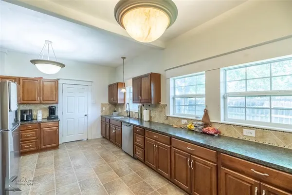 a kitchen with stainless steel appliances granite countertop a stove a sink and a refrigerator