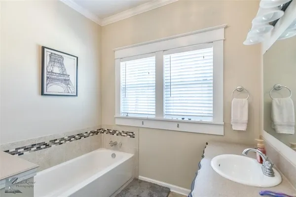 a bathroom with a tub a sink and a window