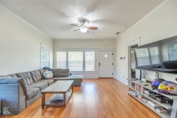 a living room with furniture and a wooden floor