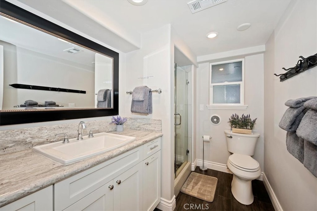 27550 North Bay Road Lake Arrowhead, CA 92352 - Photo 20 of 32 a bathroom with a granite countertop toilet sink and shower
